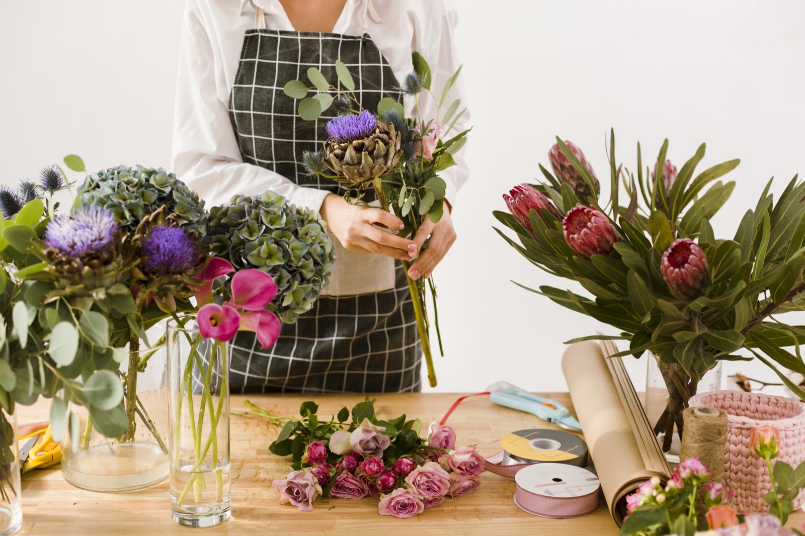 Florista preparando un arreglo sobre su mesa de trabajo